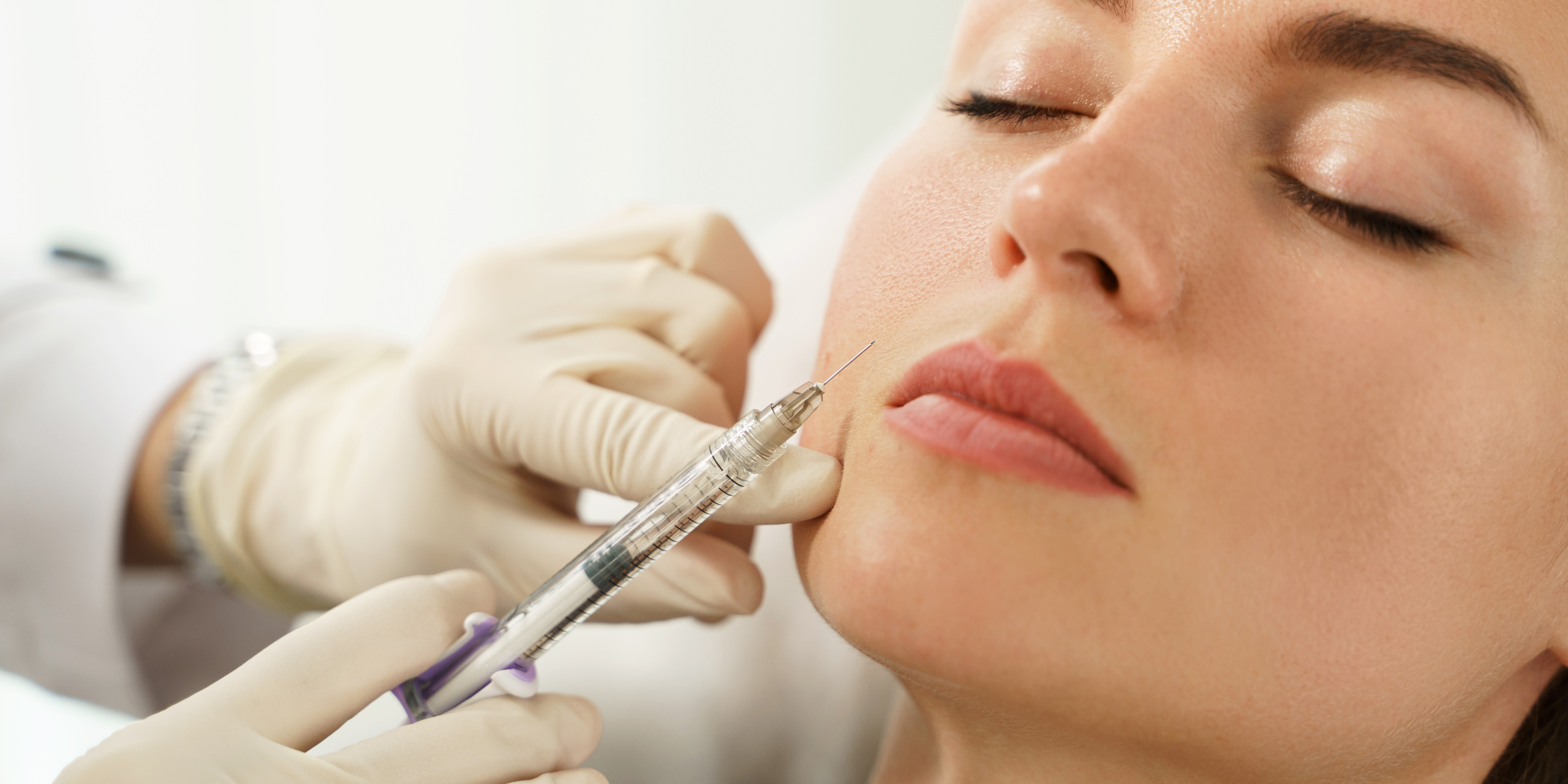 Aesthetic Nurse injecting dermal filler into a woman's face.