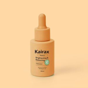 A 30ml bottle of Kairax Brightening & Balancing Serum with a peach dropper cap, featuring a label that reads "8% Ascorbic Acid + 2% Hyaluronic Acid" on a light peach background.